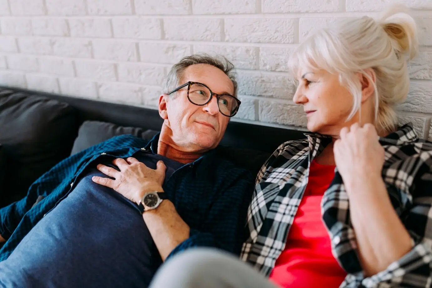 Älteres Paar auf einer Couch in einem Seniorenheim.